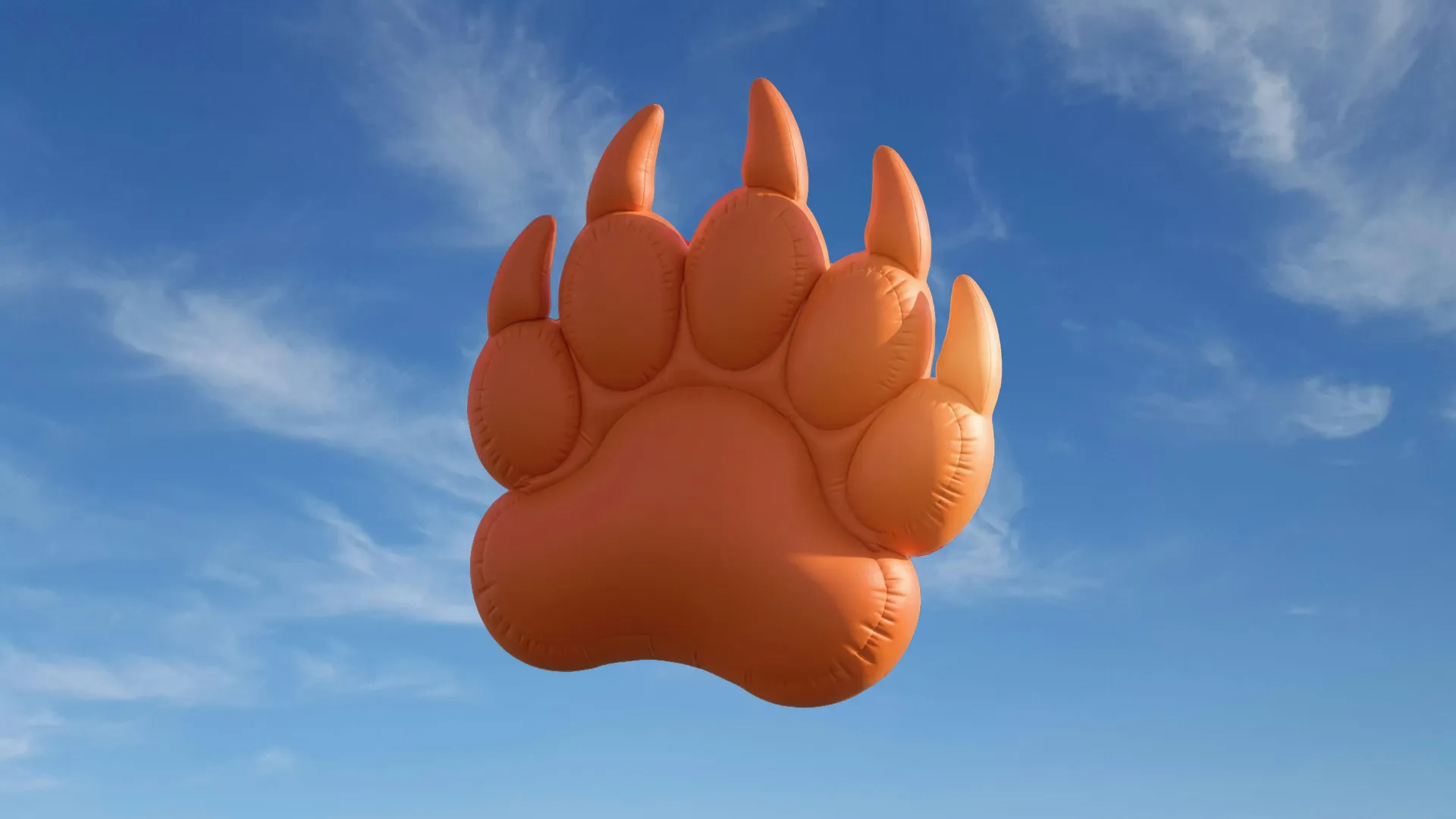 An inflatable bear paw floating in a blue sky